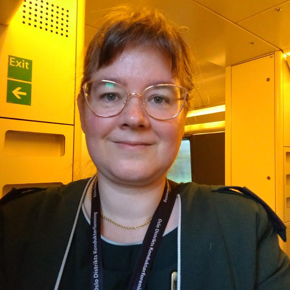 A selfie of a woman on a train in work uniform.