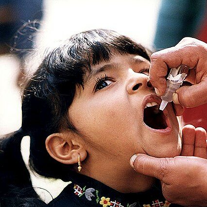 A young girl receives an Oral Polio Vaccine