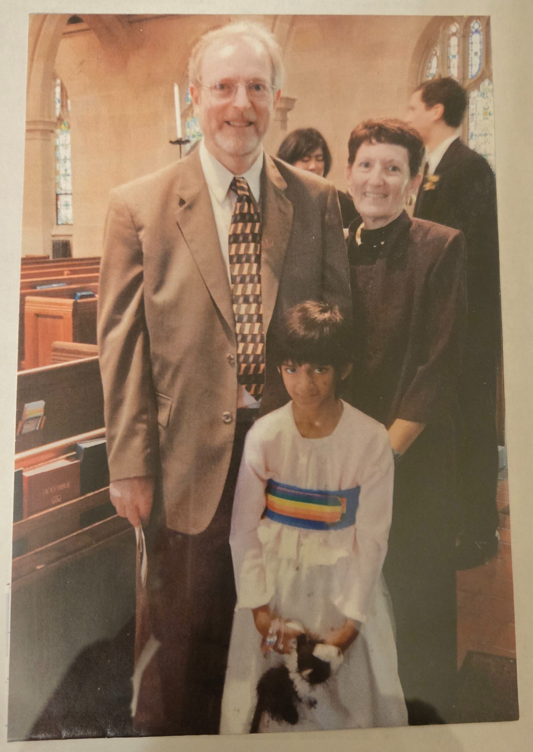 Brian, Erica and Emmalee stand together in formal clothes in a church.